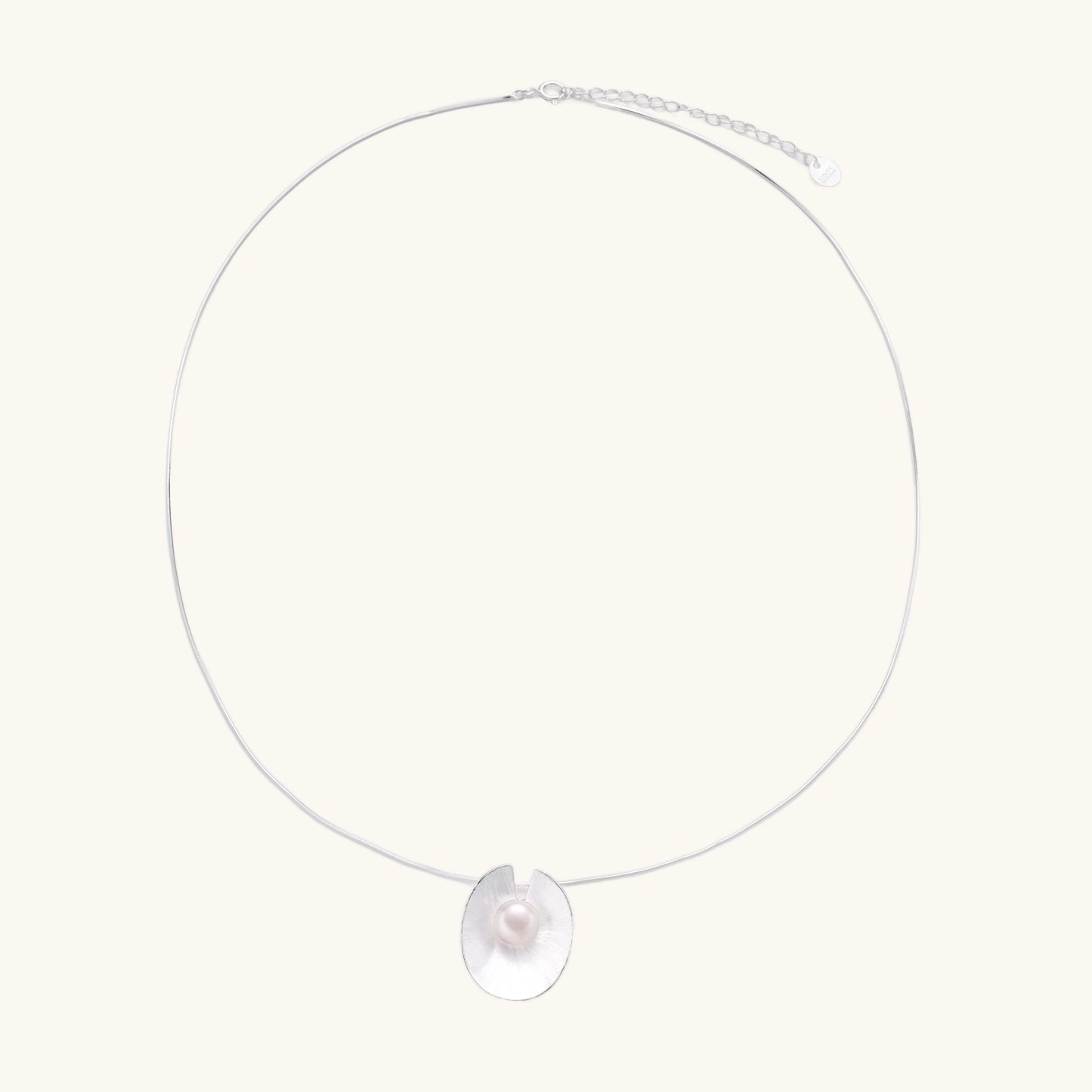 Delicate sterling silver necklace with oval iridescent pendant and central freshwater pearl on white background