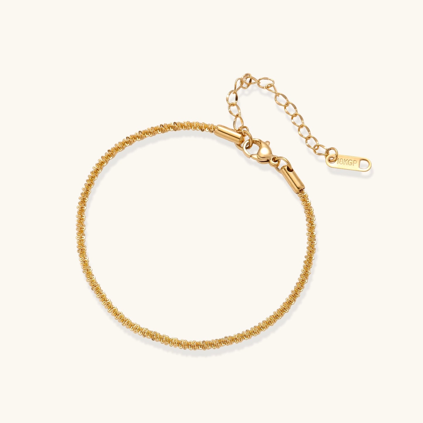 Delicate 18K gold plated stainless steel chain bracelet with textured links and adjustable extender on neutral background.