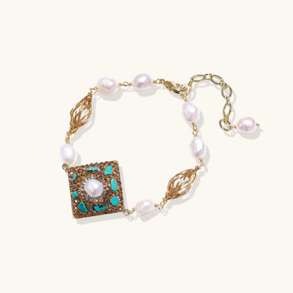 Ornate gold-plated bracelet with square turquoise and crystal centerpiece, freshwater pearls, and decorative chain links