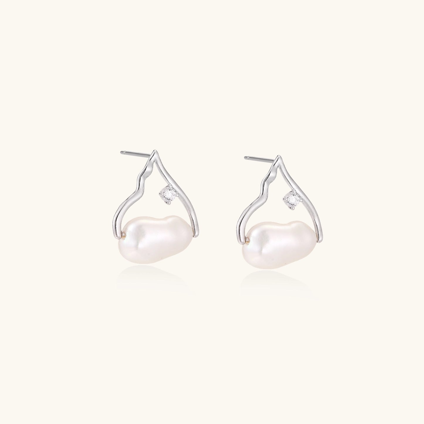 Sterling silver teardrop-shaped stud earrings with white freshwater pearls nestled in elegant flame-like frames