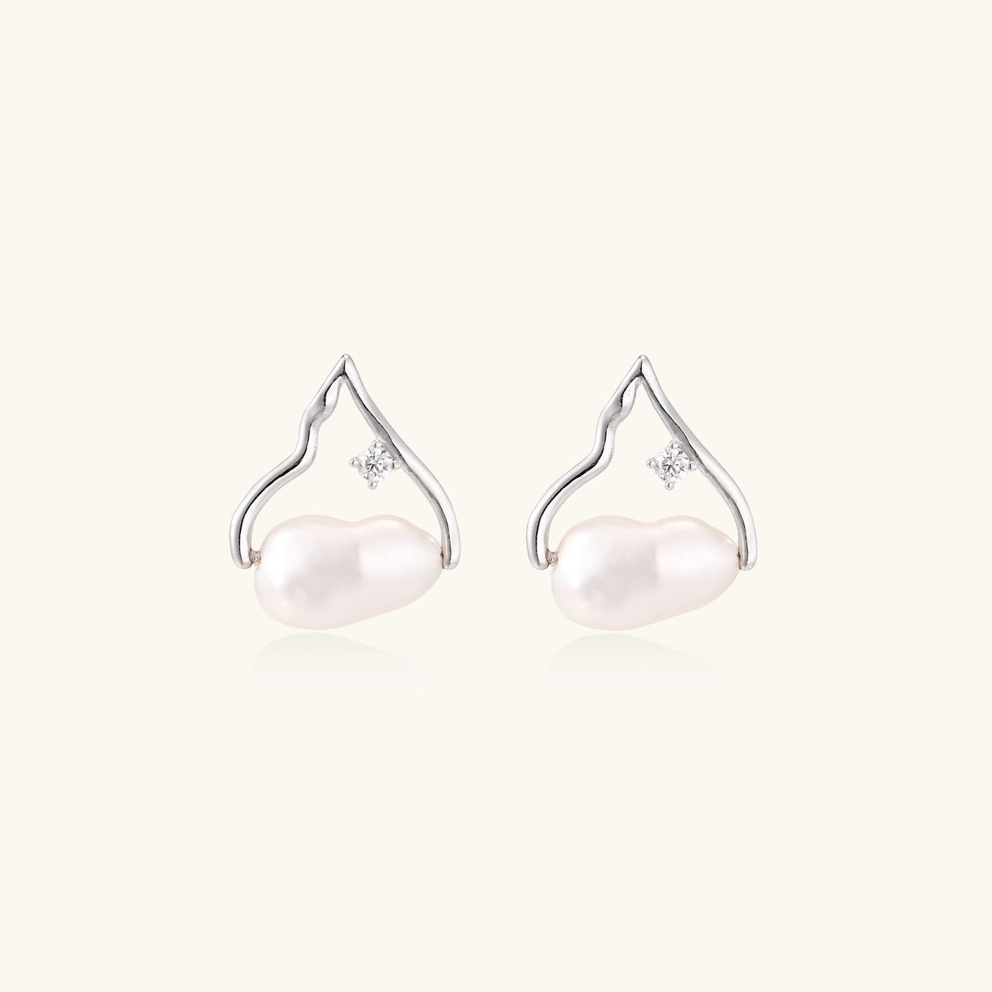 Sterling silver teardrop-shaped stud earrings with white freshwater pearls nestled in elegant flame-like frames