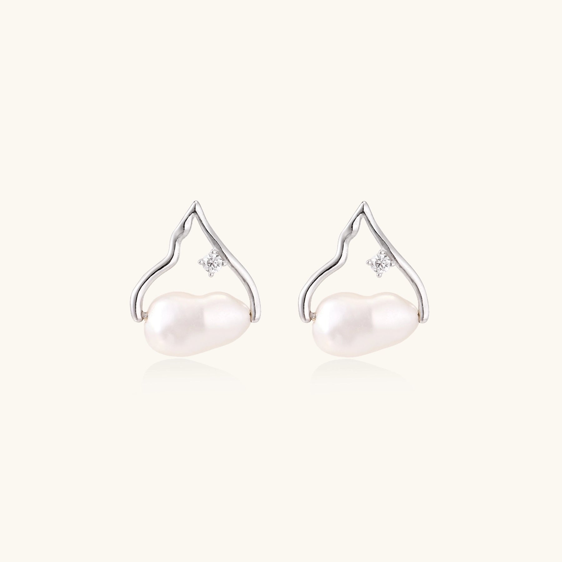 Sterling silver teardrop-shaped stud earrings with white freshwater pearls nestled in elegant flame-like frames