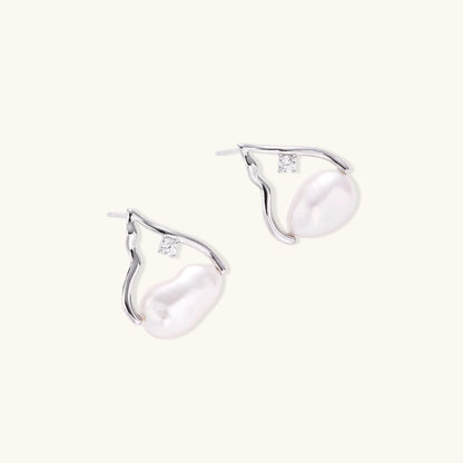 Sterling silver teardrop-shaped stud earrings with white freshwater pearls nestled in elegant flame-like frames