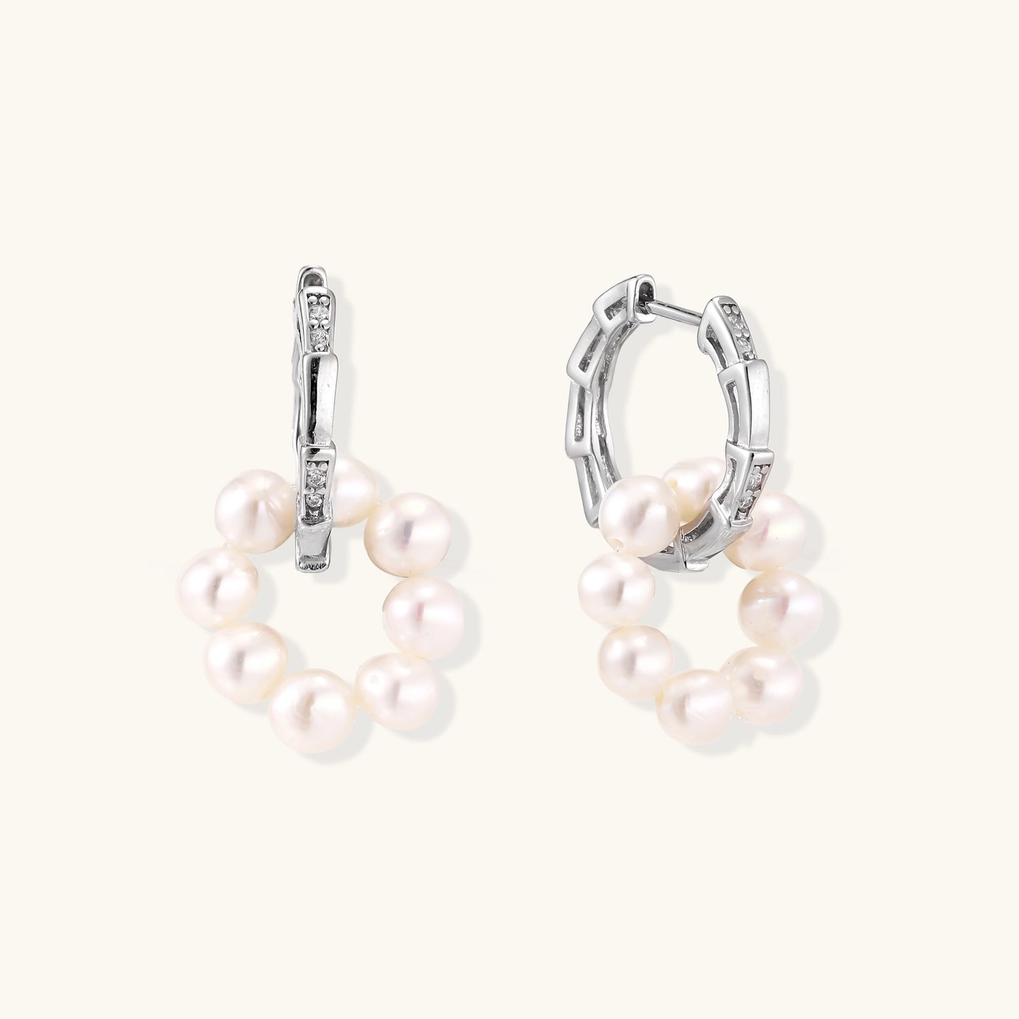 Sterling silver huggie hoop earrings with clustered white freshwater pearls and crystal accents on white background.