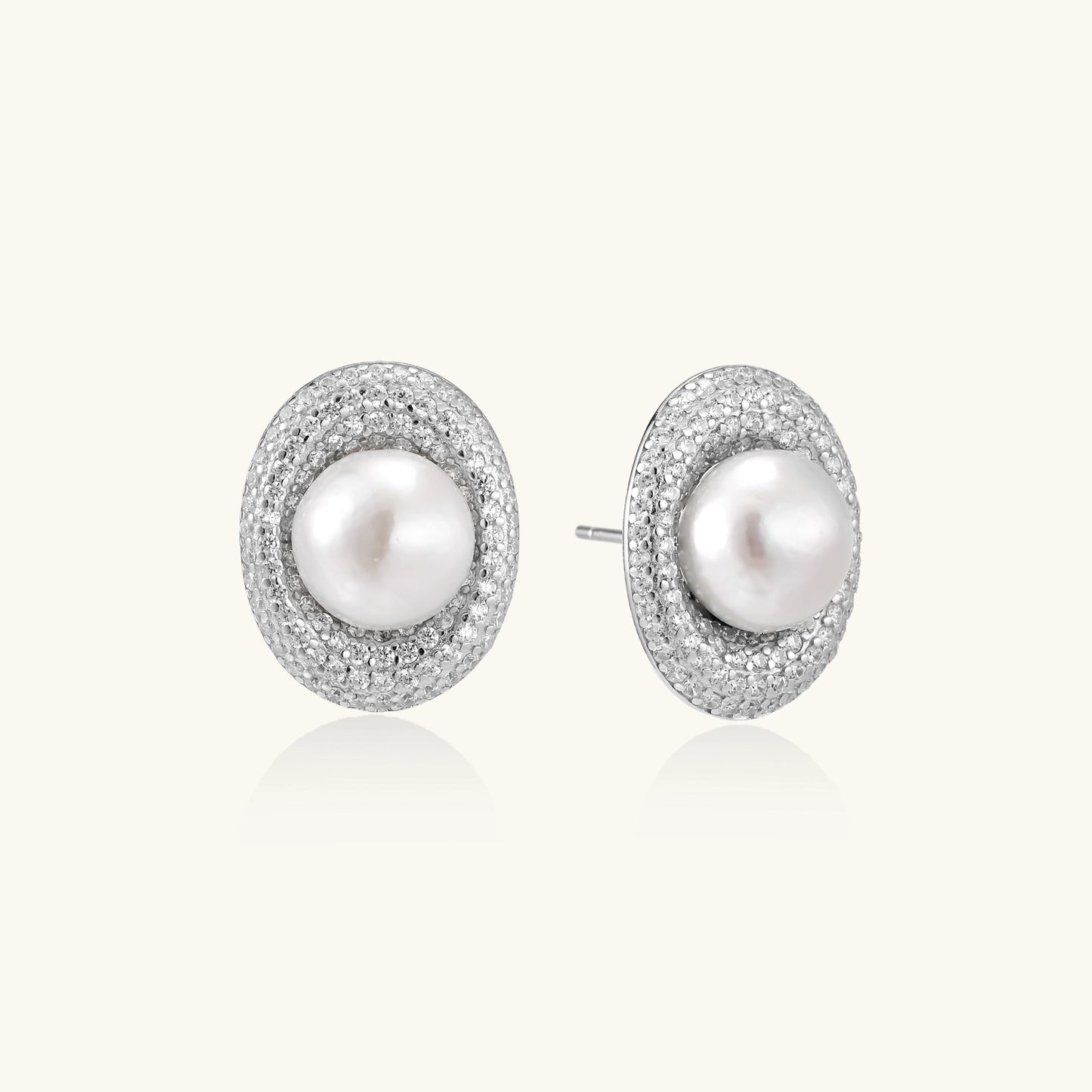 Sterling silver stud earrings with freshwater pearls surrounded by sparkling pavé crystals on white background.