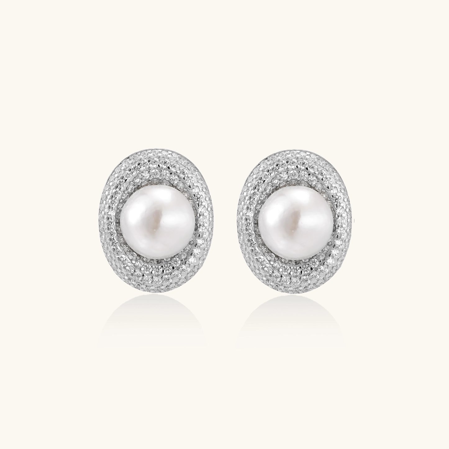 Sterling silver stud earrings with freshwater pearls surrounded by sparkling pavé crystals on white background.