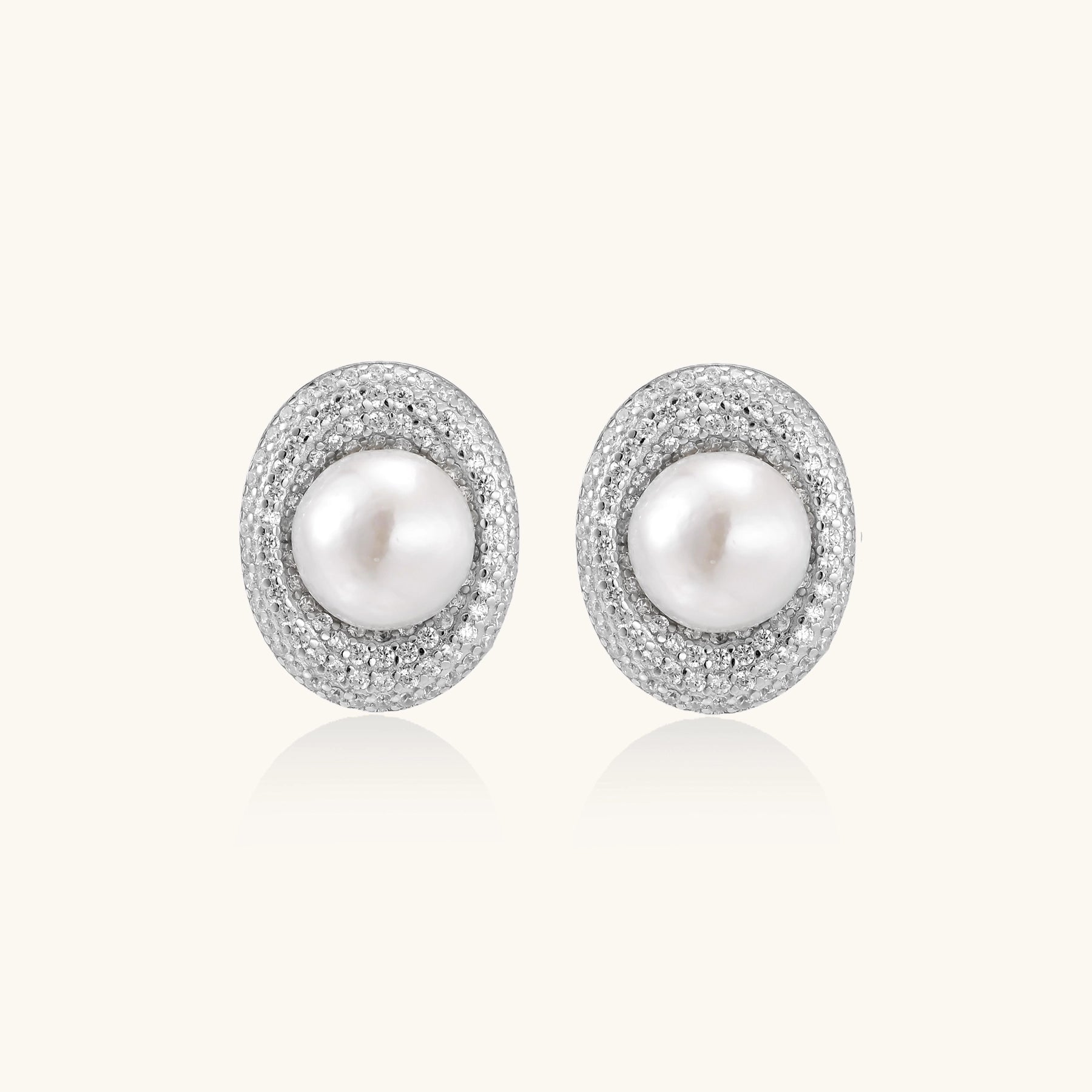 Sterling silver stud earrings with freshwater pearls surrounded by sparkling pavé crystals on white background.