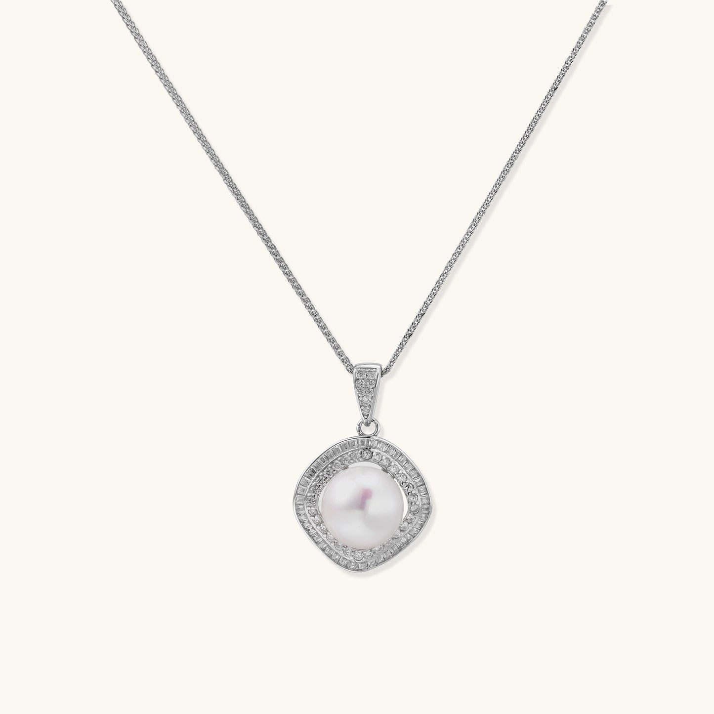Sterling silver necklace with geometric halo setting surrounding a 10mm freshwater pearl on white background.