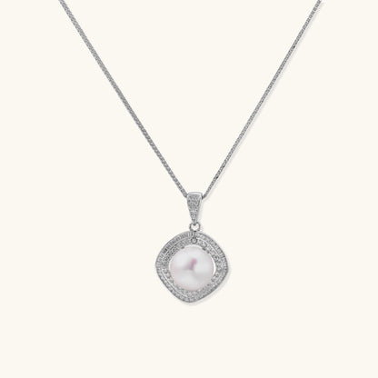 Sterling silver necklace with geometric halo setting surrounding a 10mm freshwater pearl on white background.