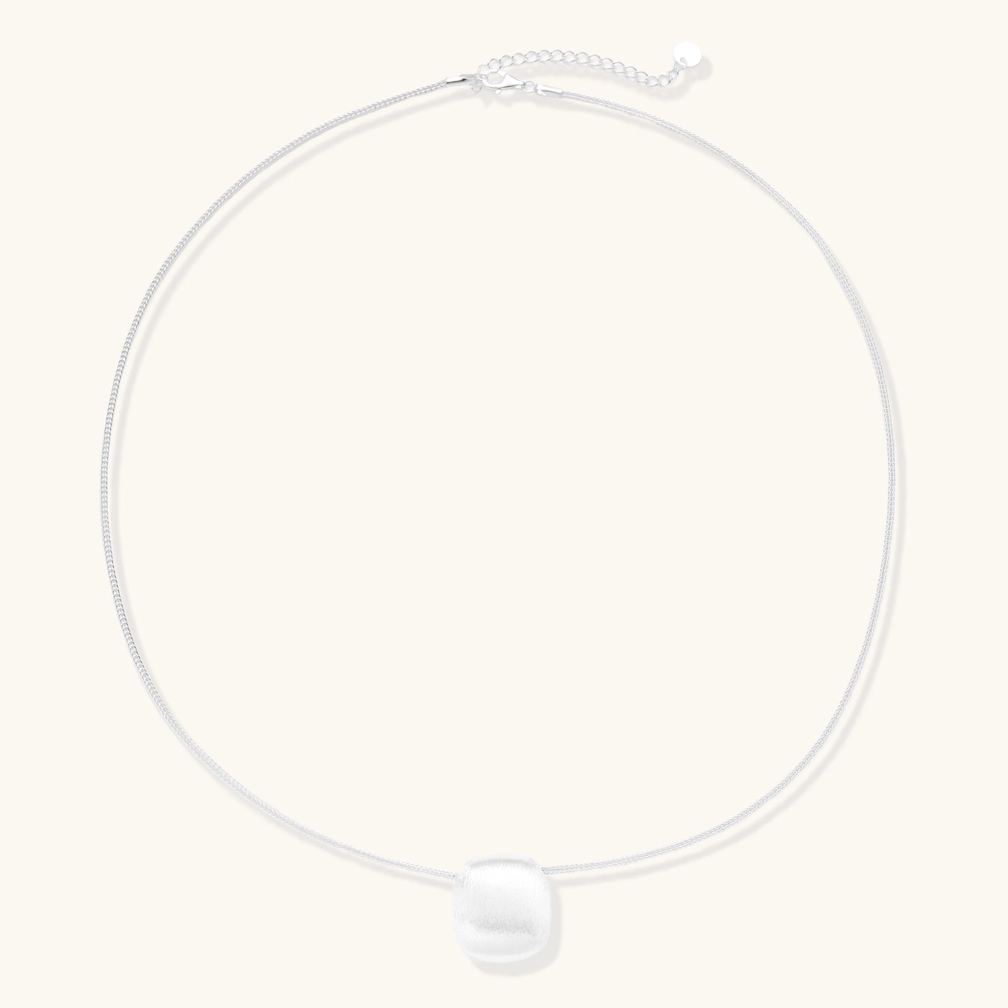 Minimalist sterling silver necklace with brushed square pendant on adjustable chain against white background.