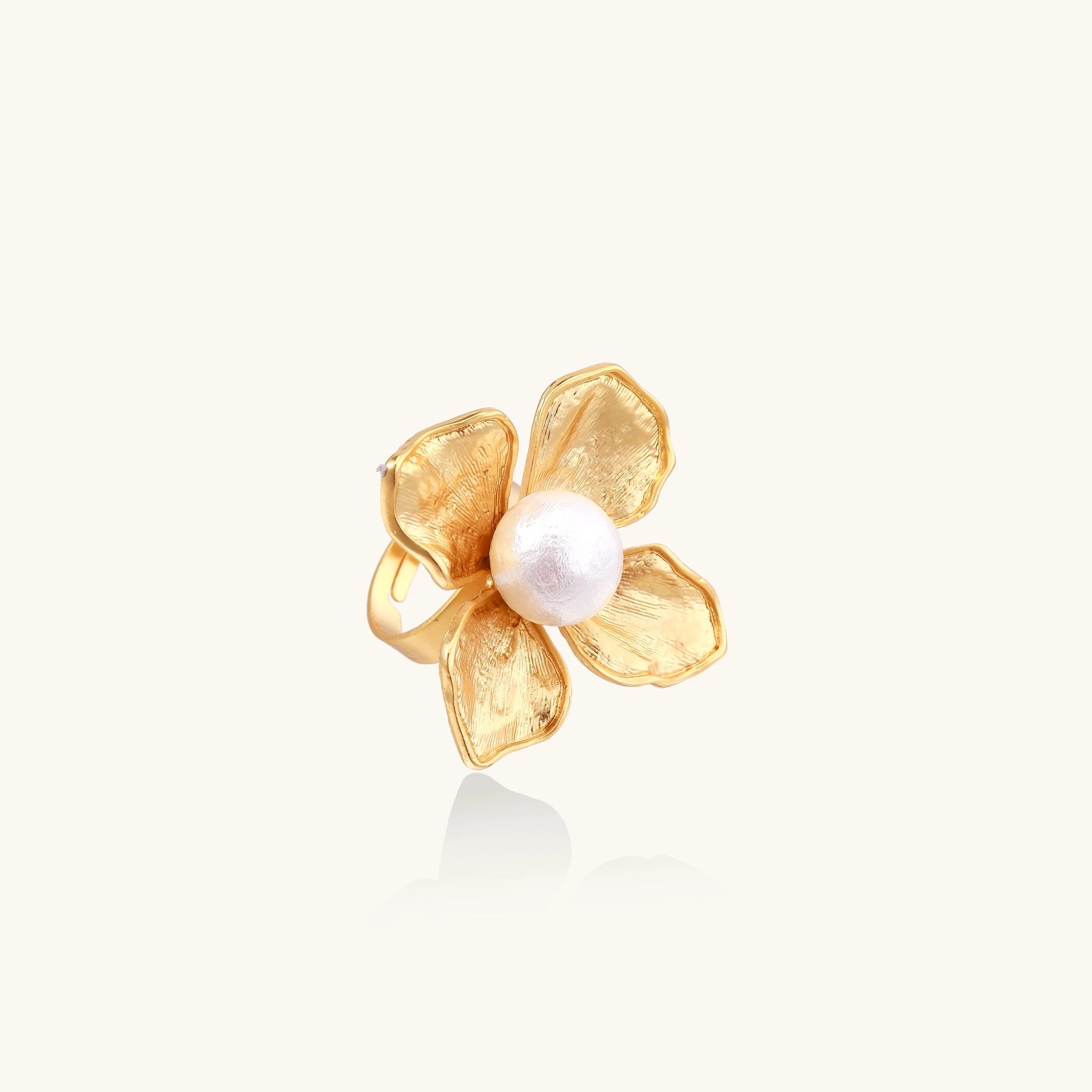Gold-plated brass ring with dimensional 5-petal flower design and white cotton pearl center on neutral background.