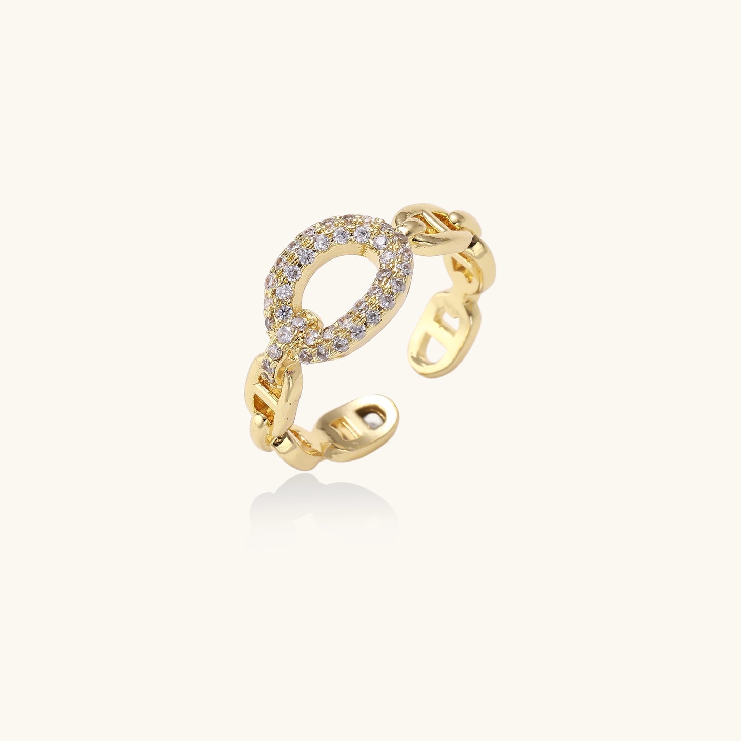 Gold-plated brass chain-link ring with cubic zirconia oval centerpiece, showing adjustable open-back design.