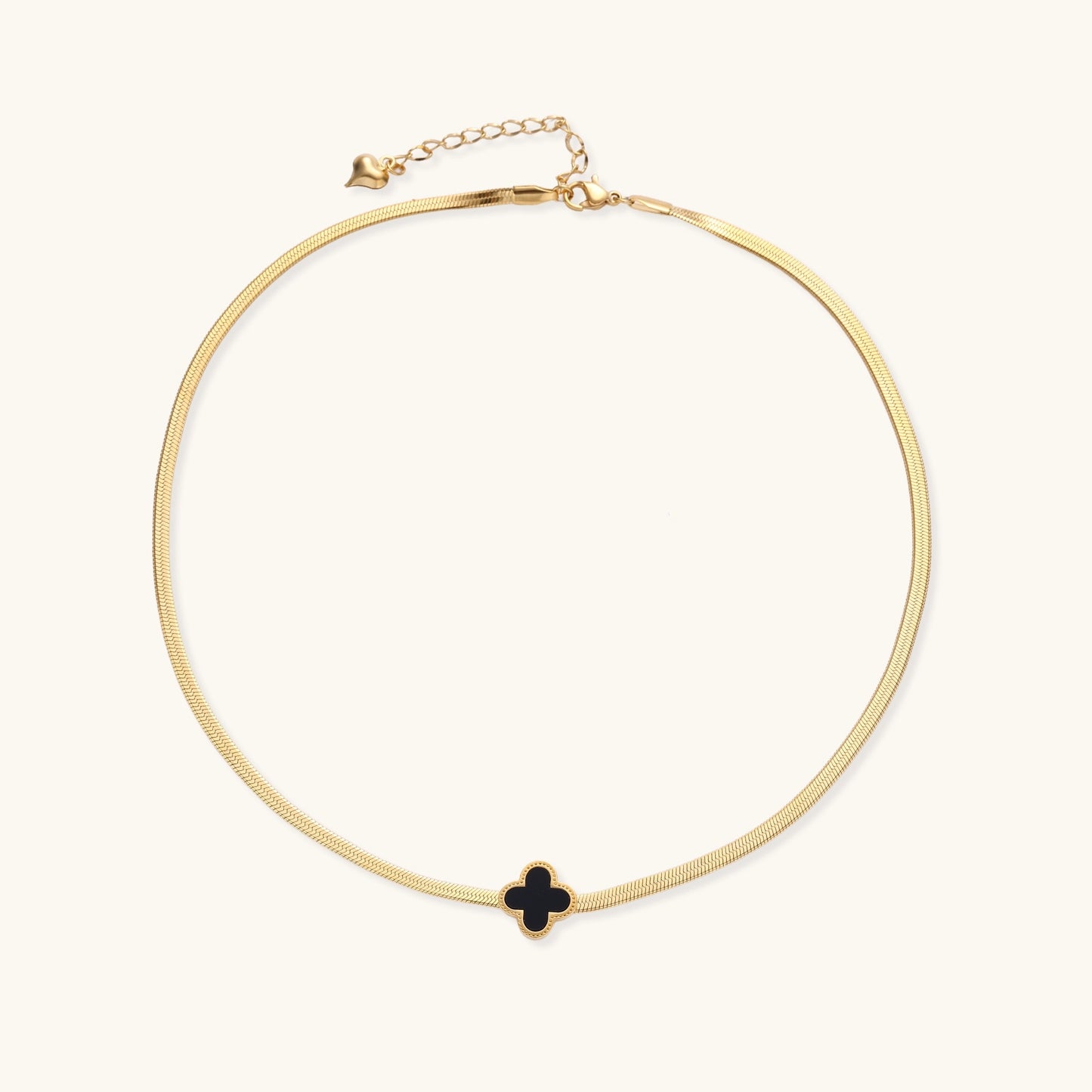 Delicate gold-plated chain necklace featuring a black quatrefoil clover pendant on white background.