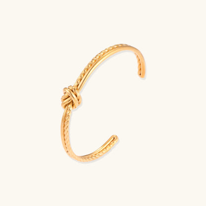 18K gold-plated twisted rope cuff bracelet with decorative knot detail on white background, showing adjustable open design.